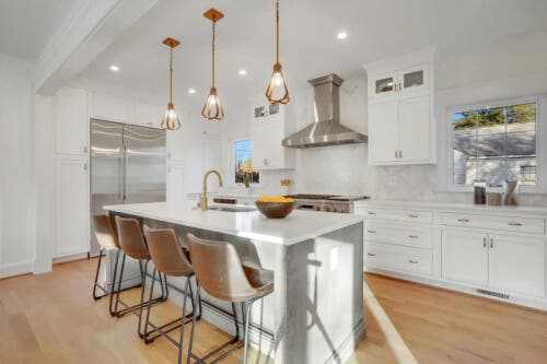 Fitzgerald Sea Salt and Cherry Peppercorn Large U-shaped white inset kitchen design with stacked glass cabinets and a gray stained island.