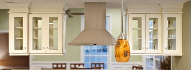 kitchen cabinets with glass doors on both sides and ornate crown molding