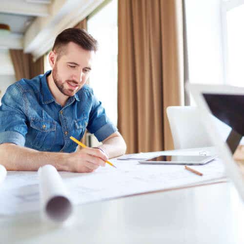 Kitchen designer hand-drafting floor plans on a desk Kitchen designer hand-drafting floor plans on a desk