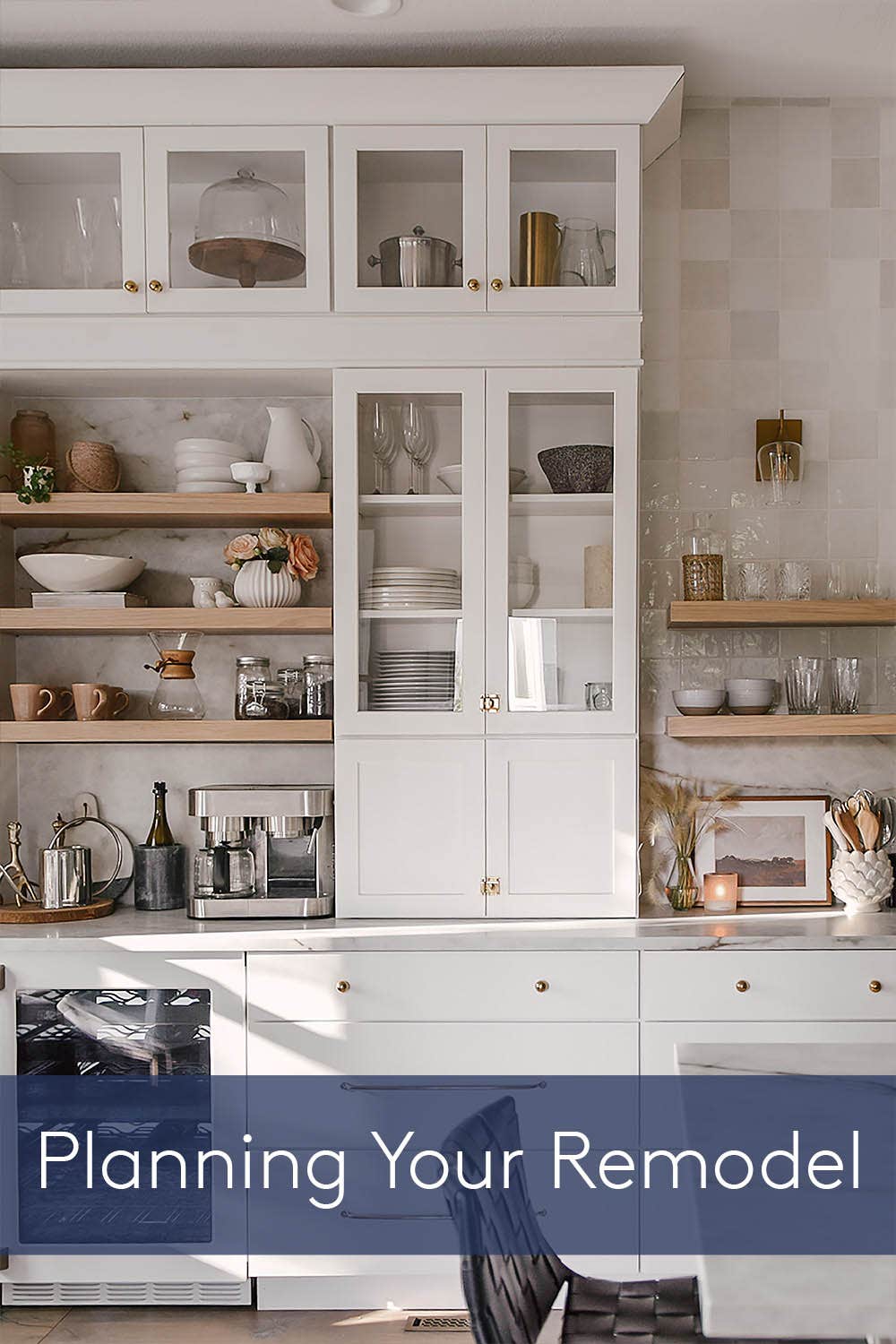 White shaker kitchen baking center with stacked glass cabinets and natural maple wood floating shelves