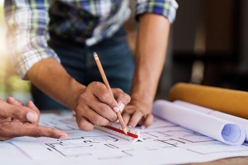 Two people collaborating on design drawings Two people collaborating on design drawings