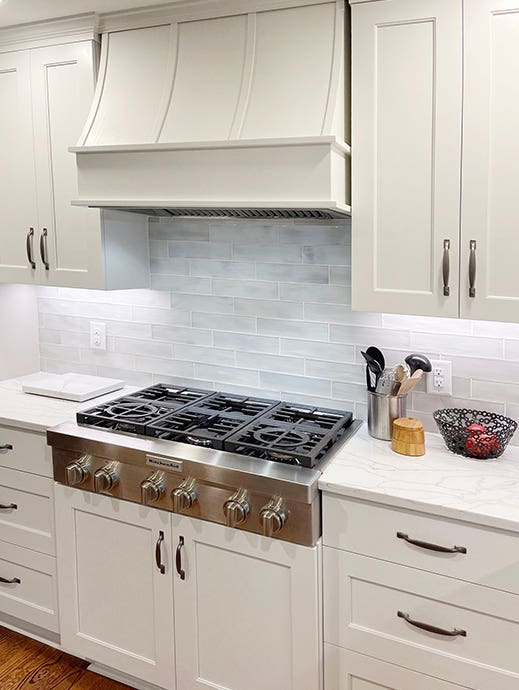 Cream shaker kitchen with sloped wood kitchen hood and wood strapping Cream shaker kitchen with sloped wood kitchen hood and wood strapping
