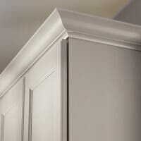 Tall Molding Decorative white kitchen cabinets with transitional curvy crown molding above.