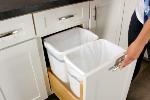 White shaker kitchen cabinets with a pull-out trash cabinet White shaker kitchen cabinets with a pull-out trash cabinet
