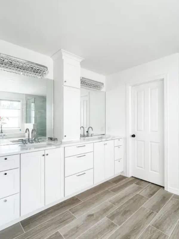 White shaker bathroom vanity with matching tall bathroom storage cabinet above White shaker bathroom vanity with white countertops