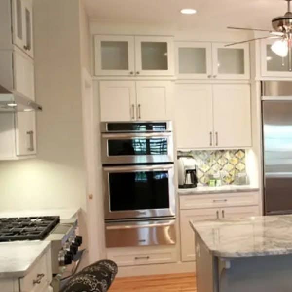 White shaker kitchen with stacked glass cabinets White shaker kitchen with stacked glass cabinets and wall oven with warming drawer