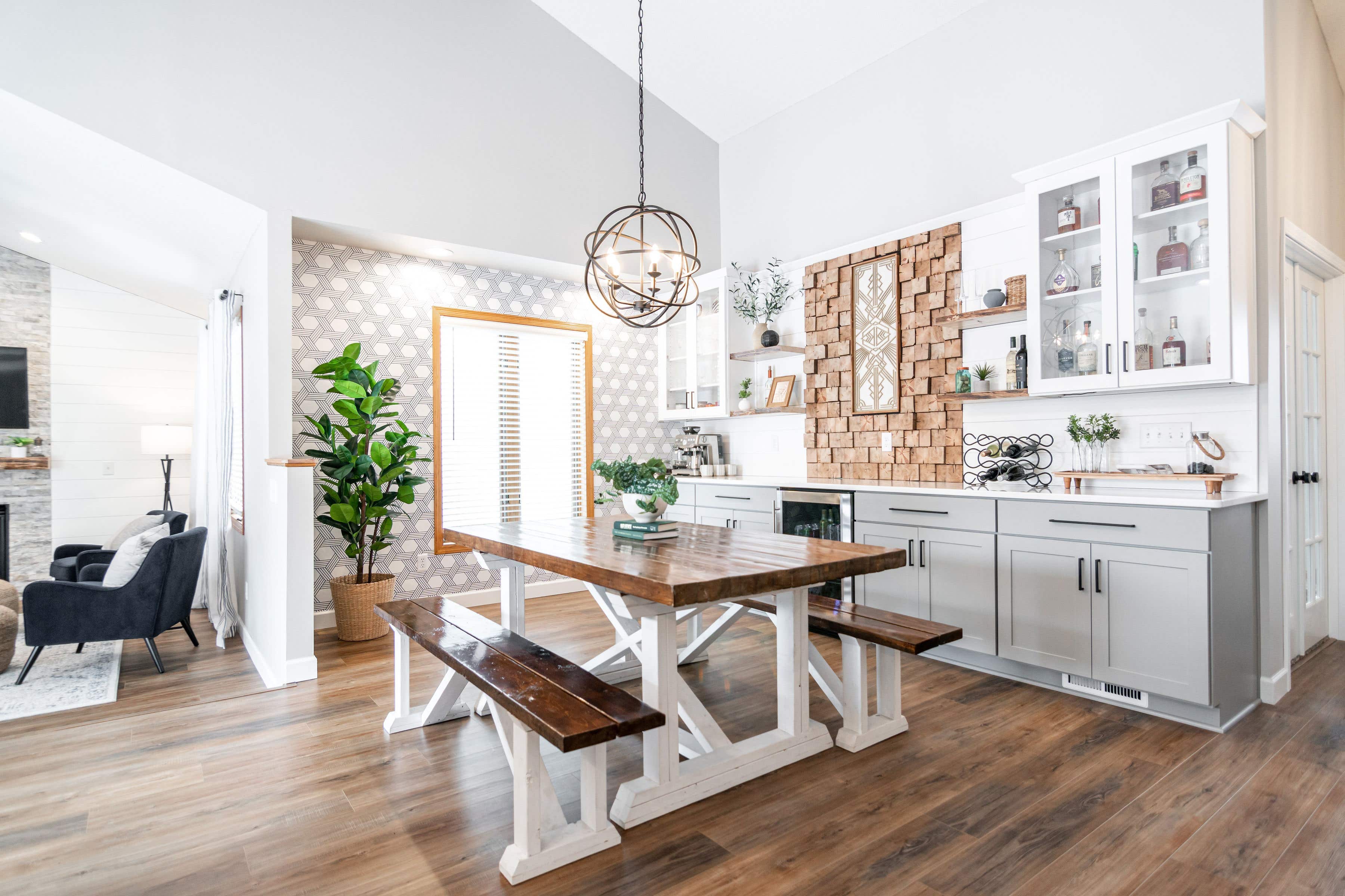 CliqStudios project: White and light gray shaker buffet cabinets and white subway tile backsplash and geometric wall paper