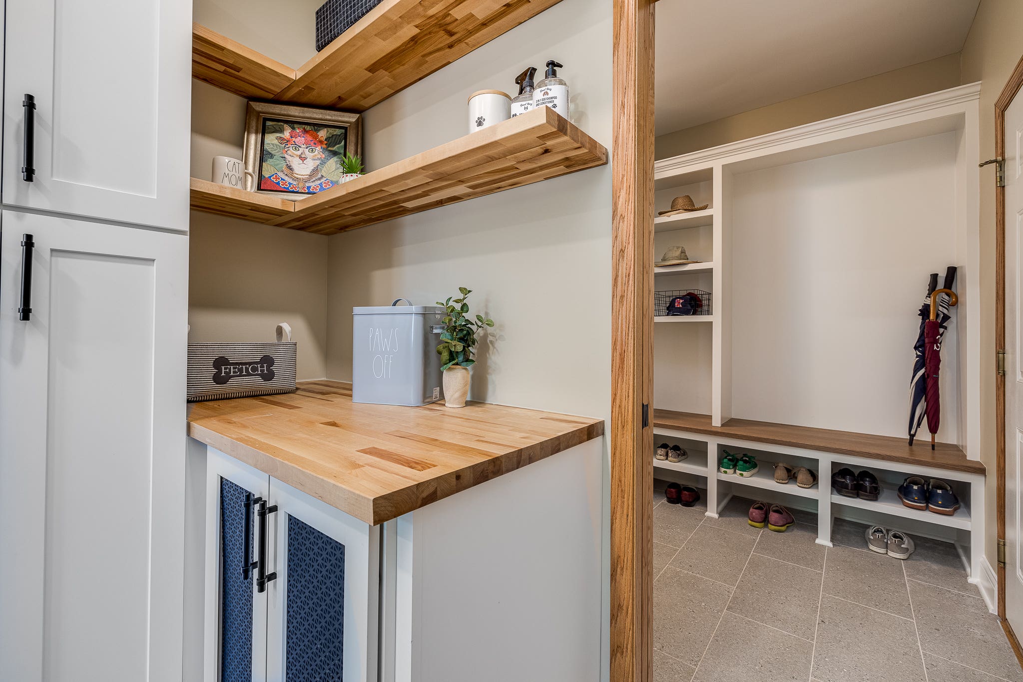 CliqStudios project: Shaker white laundry room sink cabinets with black hardware pulls and light butcher block countertops