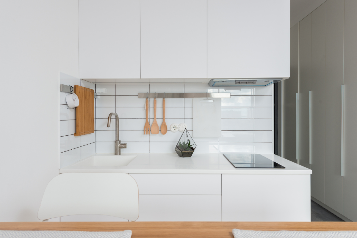 White slab door mini kitchen with small appliances and a white subway tile backsplash White slab door mini kitchen with small appliances and a white subway tile backsplash