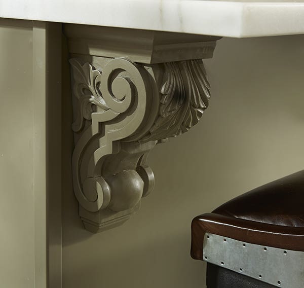 Ornate olive green countertop support corbel next to metal bar stool