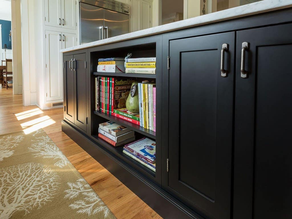 kitchen island built of black shaker cabinets with open bookshelves