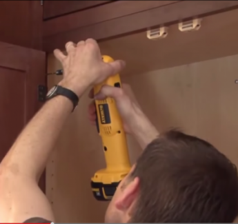 Kitchen Cabinet Installers - A man installing kitchen cabinets. Kitchen Cabinet Installers - A man installing kitchen cabinets.