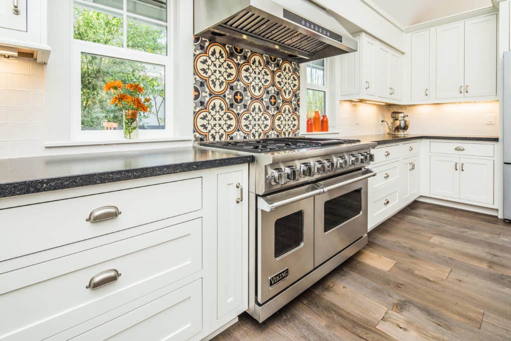 Inset white shaker kitchen cabinets with a large stainless steel chef's range Inset white shaker kitchen cabinets with a large stainless steel chef's range