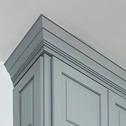 A traditional crown Molding on Decorative cabinets painted in blue-gray.