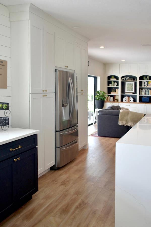 CLiqStudios Shaker cabinets in white, and in the center is a refrigerator. Next to it, base Shaker cabinets are in Black with white countertop. CLiqStudios Shaker cabinets in white, and in the center is a refrigerator. Next to it, base Shaker cabinets are in Black with white countertop.