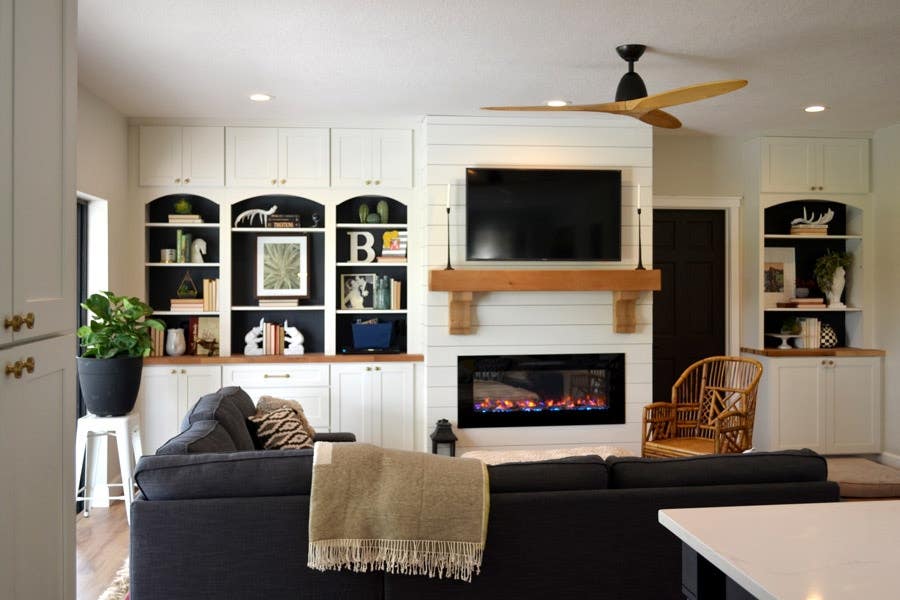 Living area using CliqStudios Shaker cabinets in White around the entertainment area for added storage. Base cabinets have butcher board countertops, above them is open air shelving, and flush with the ceiling are more small cabinets. Living area using CliqStudios Shaker cabinets in White around the entertainment area for added storage. Base cabinets have butcher board countertops, above them is open air shelving, and flush with the ceiling are more small cabinets.