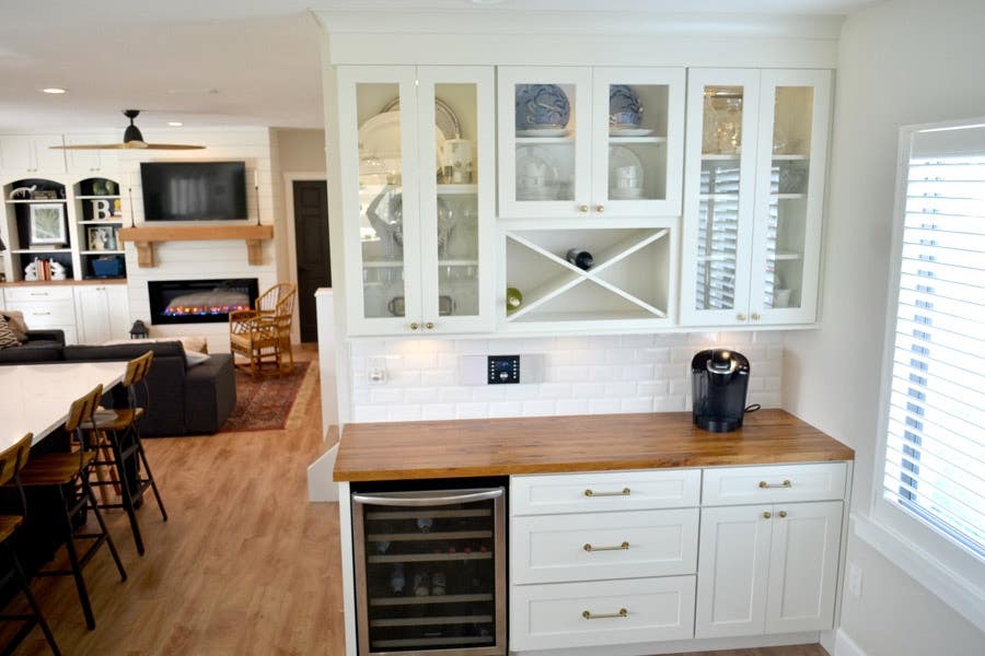 CliqStudios Dayton cabinets in white forming a butler's pantry, with a wine cooler in the base and a wine rack above centered in glass faced cabinets. CliqStudios Dayton cabinets in white forming a butler's pantry, with a wine cooler in the base and a wine rack above centered in glass faced cabinets.