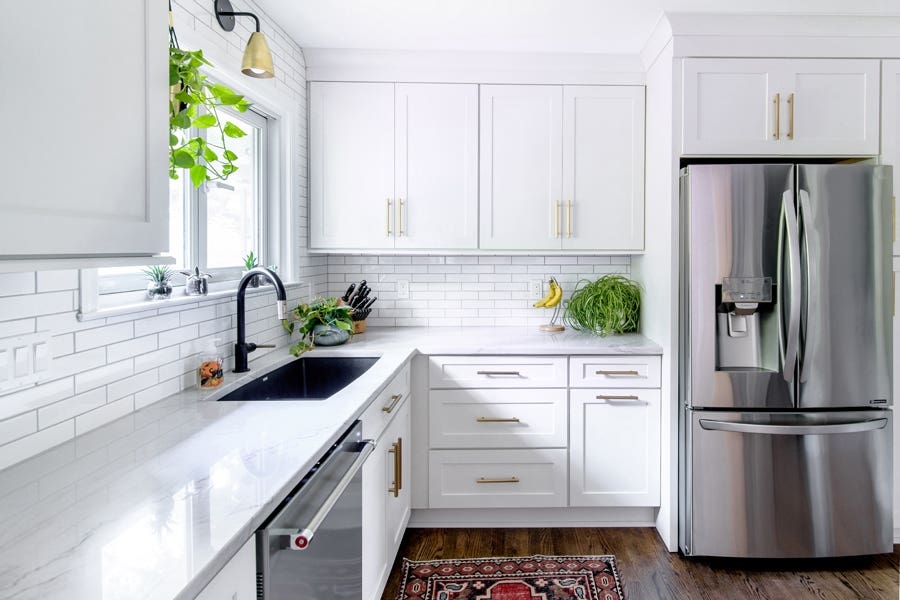 A kitchen using CliqStudios Shaker cabinets in White, with stainless steel appliances and green plant accent pieces. A kitchen using CliqStudios Shaker cabinets in White, with stainless steel appliances and green plant accent pieces.
