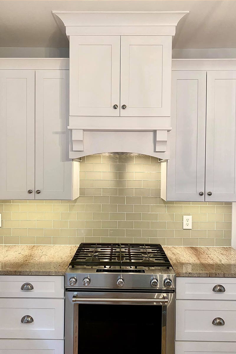 White double-door wood hood in shaker style with arched cabinet valance at the bottom White double-door wood hood in shaker style with arched cabinet valance at the bottom