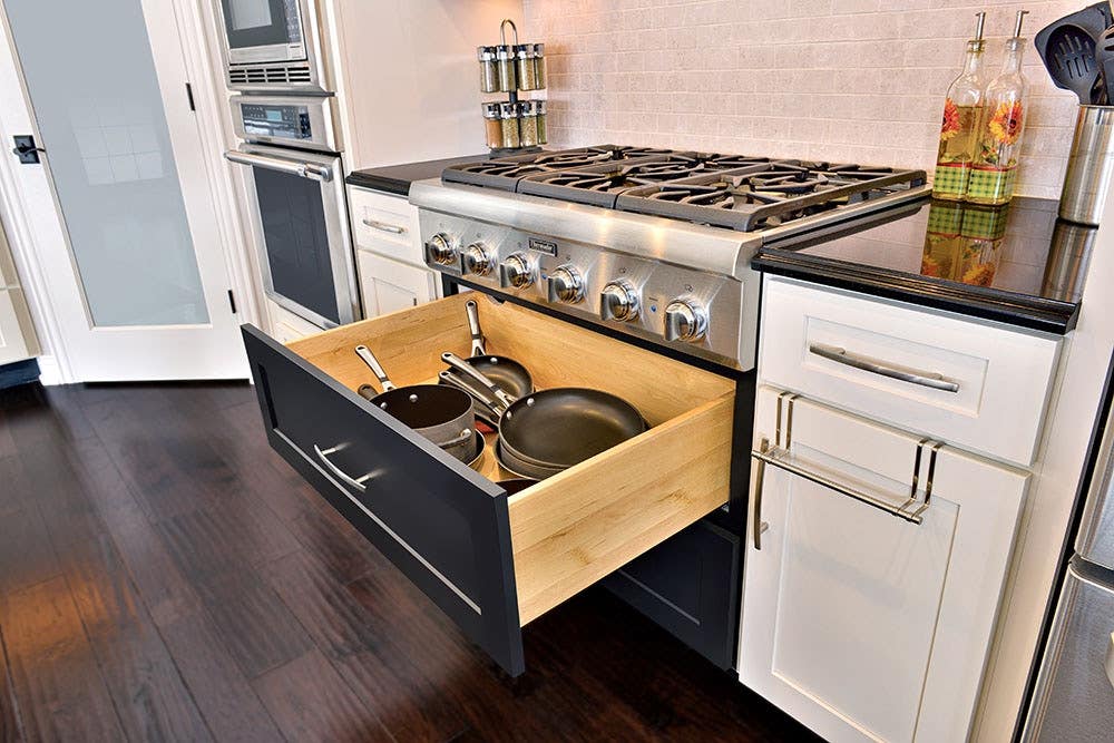 black and white cabinets with pan and pot storage drawer under professional cooktop