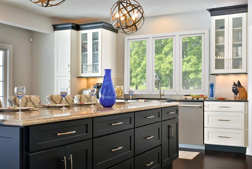 Beautifully designed open floor plan kitchen features painted shaker style cabinetry by CliqStudios. Shown shaker cabinet style in painted White finish and paired with Shaker in painted Black finish. Beautifully designed open floor plan kitchen features painted shaker style cabinetry by CliqStudios. Shown Shaker cabinet style in painted White finish and paired with Shaker in painted Black finish.
