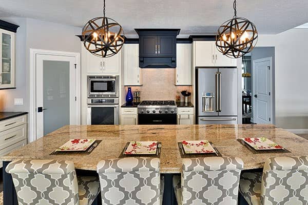 Two toned black and white kitchen with kitchen island and hanging pendant lights