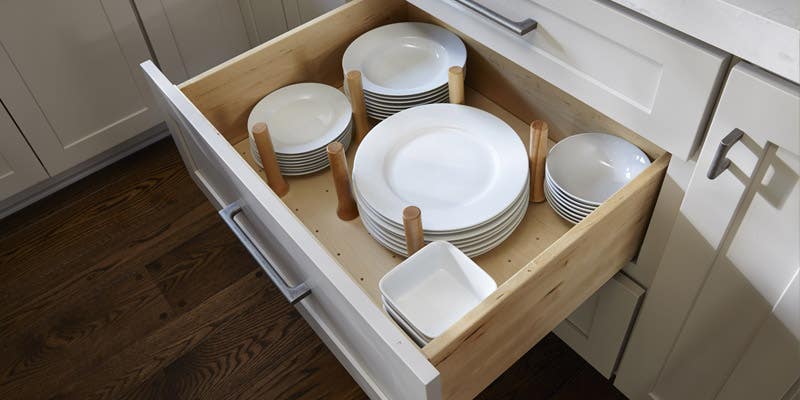 Peg drawer organizer storing plates, dishes, and bowls. Shown in CliqStudios shaker style, Painted Light Gray