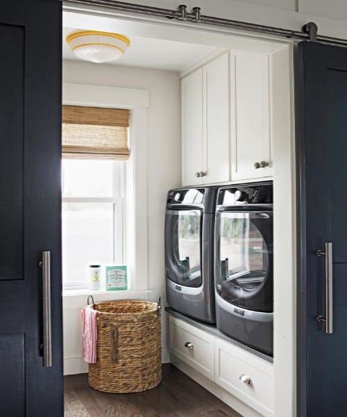 white laundry room cabinetry raised drawer storage sliding doors woven basket.