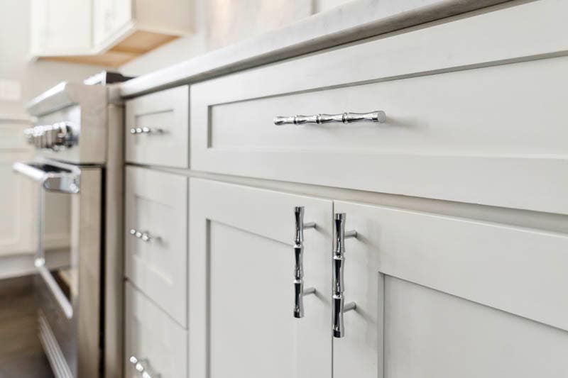 Shaker style base kitchen cabinets in taupe finish with decorative chrome pulls