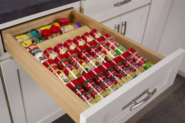 A drawer with a spice drawer insert, filled with spices. A drawer with a spice drawer insert, filled with spices.