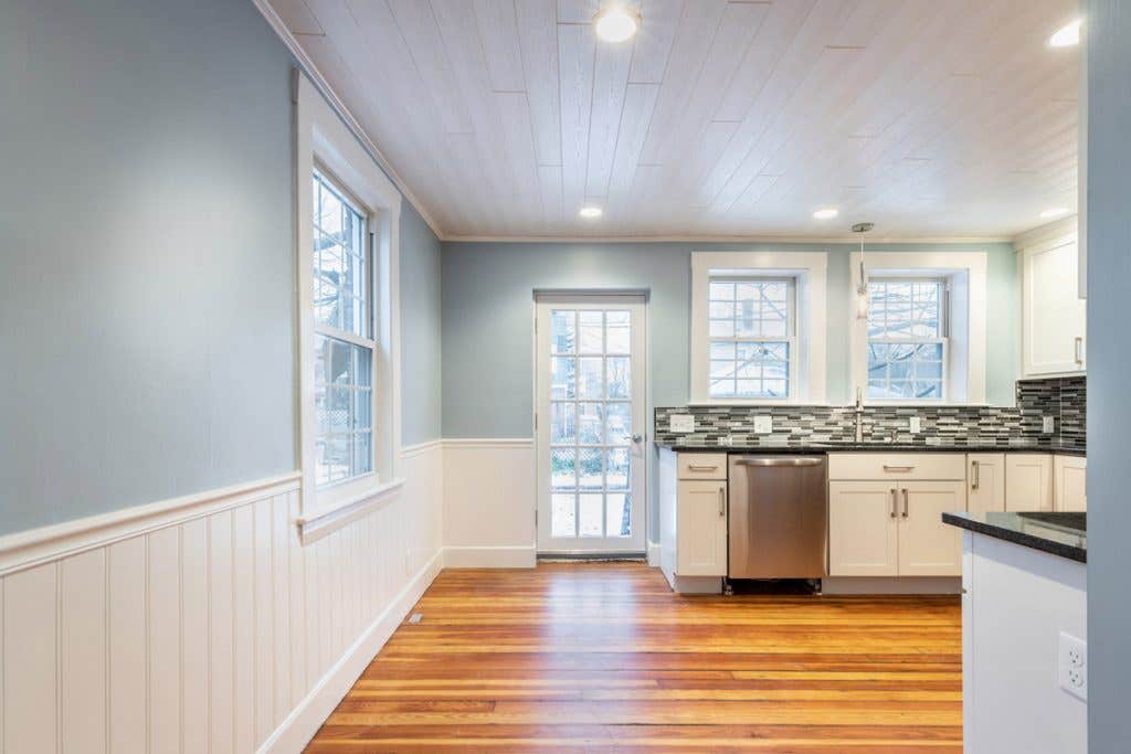 Kitchen with white cabinets and small eat-in dining area near back door Kitchen with white cabinets and small eat-in dining area near back door
