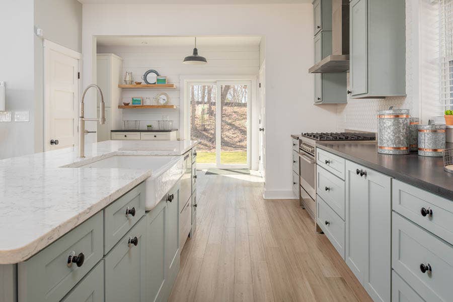 Bright kitchen in soft blue/gray shaker style with two-tone countertops and large island