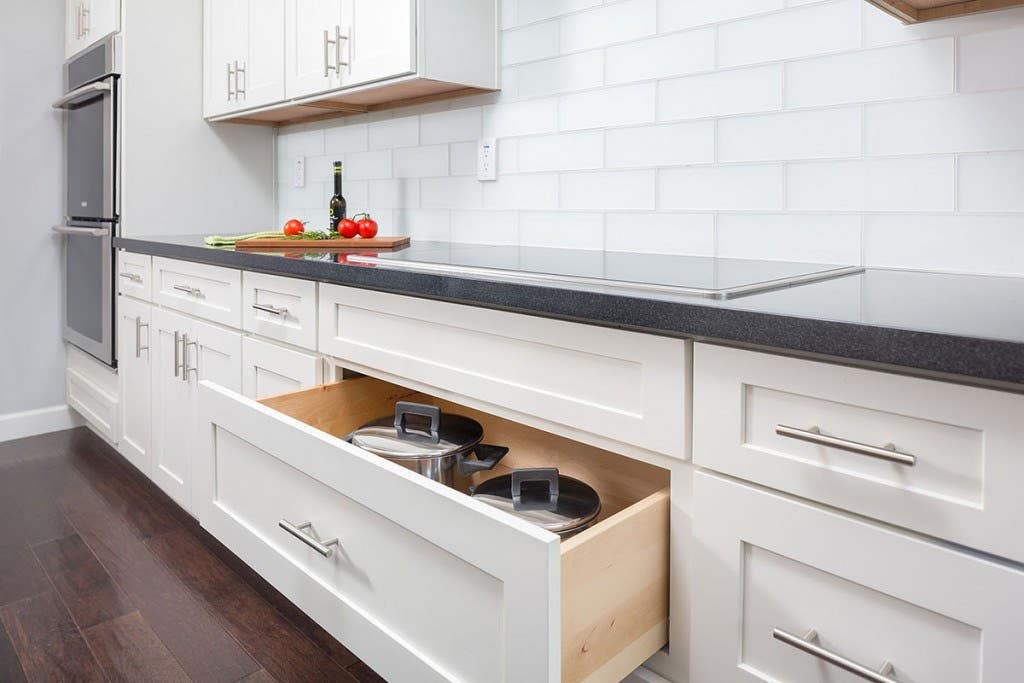 White shaker pots and pans drawer base under a cooktop