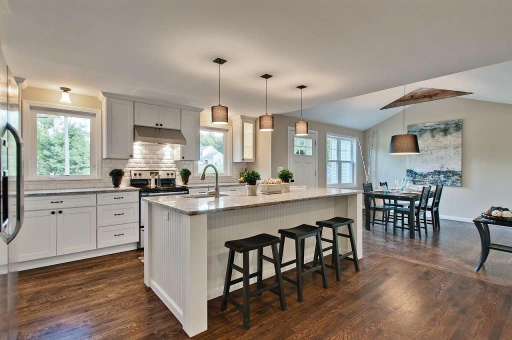 Spacious kitchen has painted white Shaker cabinets, large island with seating and a sink, opens to dining room. Spacious kitchen has painted white Shaker cabinets, large island with seating and a sink, opens to dining room.