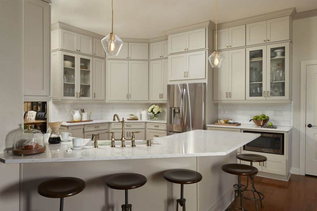 transitional gray kitchen remodeled with white countertops and glass cabinet doors