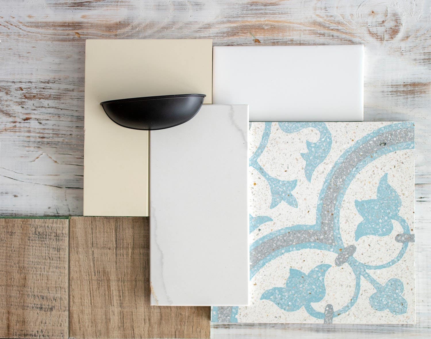 Design mood board featuring white tile, black cup pull, white cabinet sample and wood background Design mood board featuring white tile, black cup pull, white cabinet sample and wood background