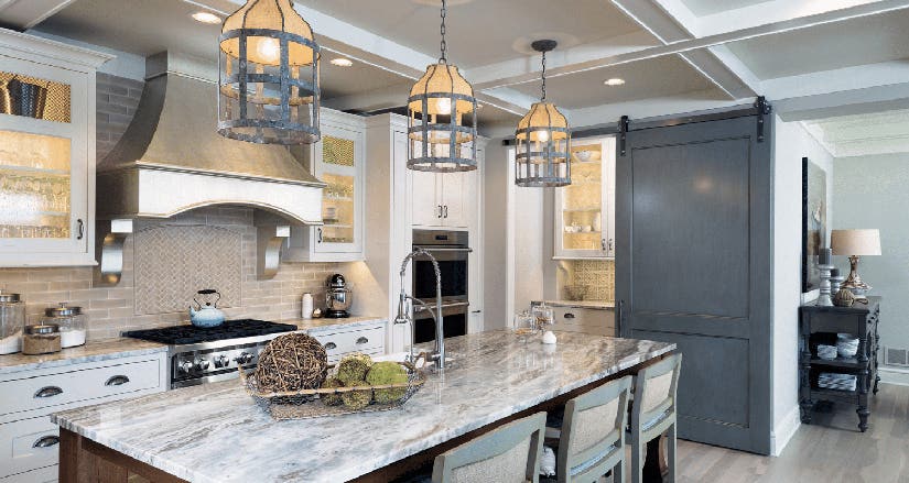 Fantasy Brown granite countertops Grand kitchen design with white shaker inset kitchen cabinets and wood-stained island with beautiful cream, gray, and brown granite countertops.