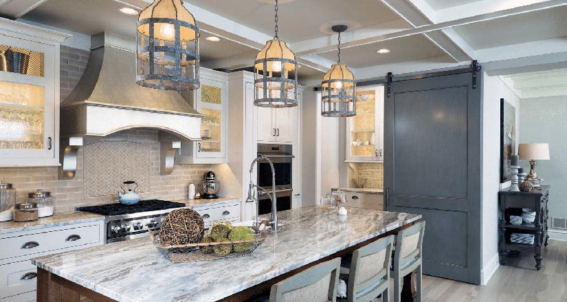 Grand kitchen design with white shaker inset kitchen cabinets and wood-stained island with beautiful cream, gray, and brown granite countertops.