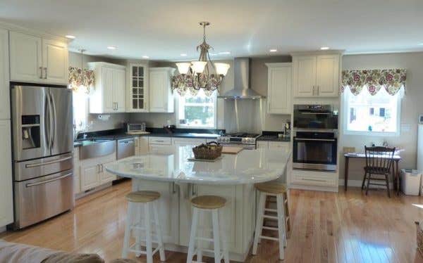 Large kitchen features CliqStudios.com Decorative raised panel cabinets in painted White finish, seating at a square island Large kitchen features CliqStudios.com Decorative raised panel cabinets in painted White finish, seating at a square island