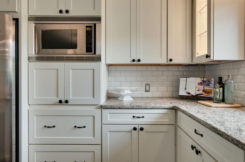 Built-In Microwave Wall Cabinet with White Kitchen Cabinets.