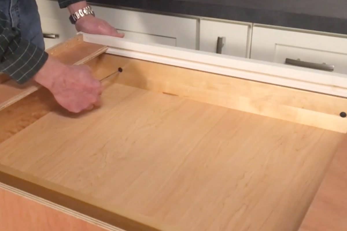 Homeowner loosening panhead screws inside a drawer box