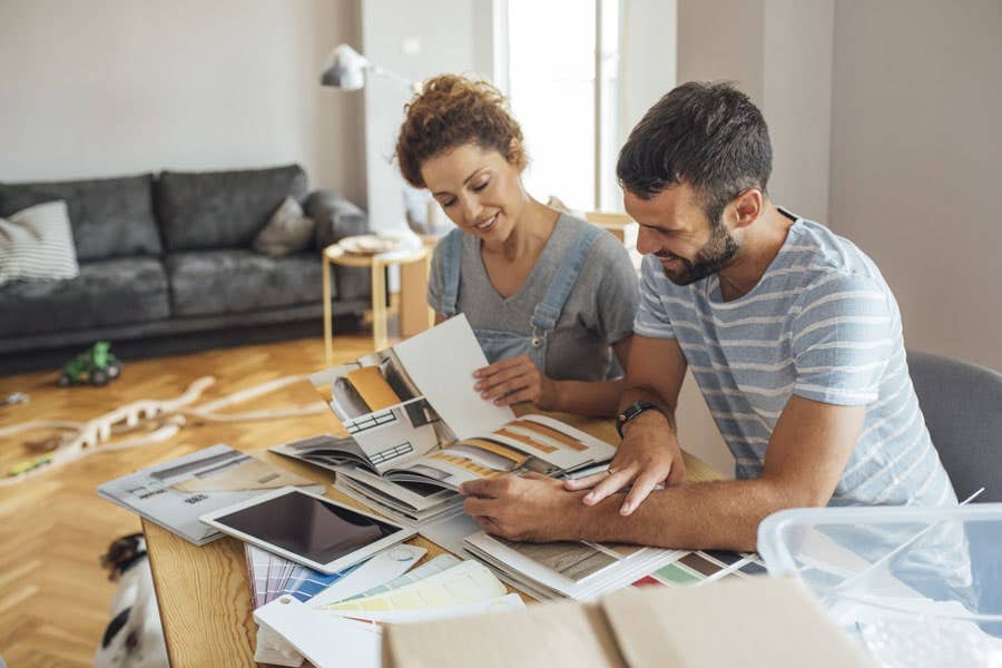 Couple sitting at kitchen table with iPad and brochures planning a remodel