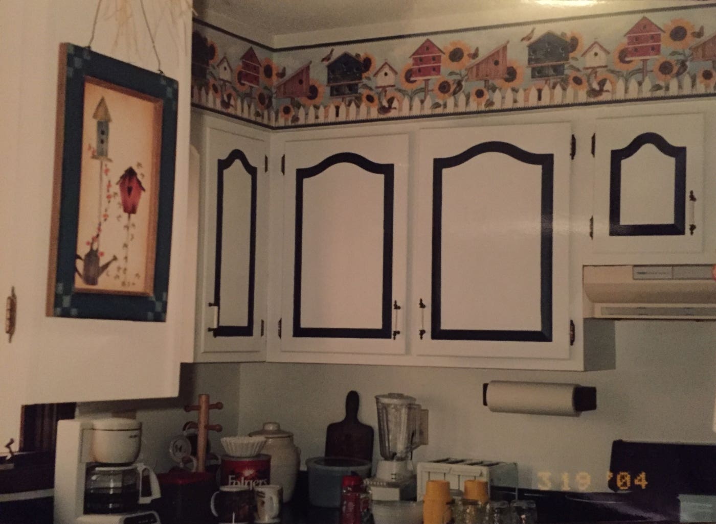 painted kitchen cabinets with cathedral doors in two-tone scheme with wallpaper trim