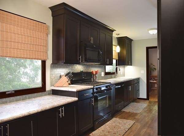 Wall of dark birch shaker cabinets includes a built-in buffet created by a lowered counter under window Wall of dark birch shaker cabinets includes a built-in buffet created by a lowered counter under window