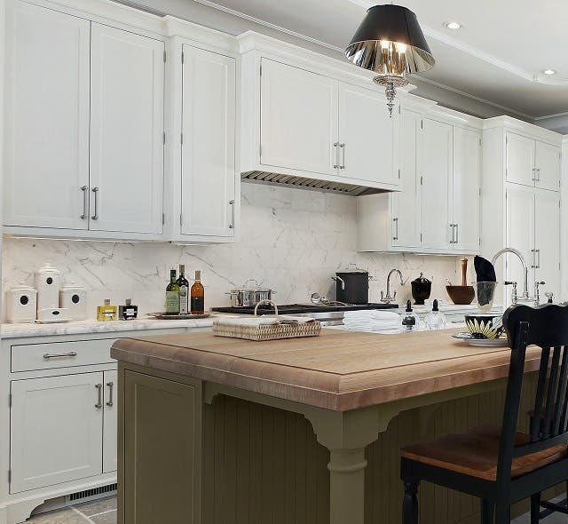 kitchen with white cabinets along the walls and green painted cabinets in the island