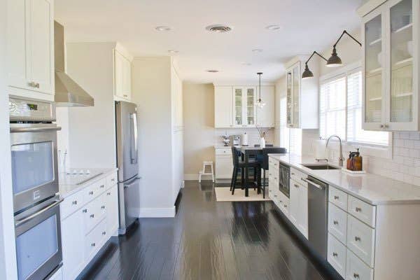 galley kitchen with white cabinets and dark hardwood floor