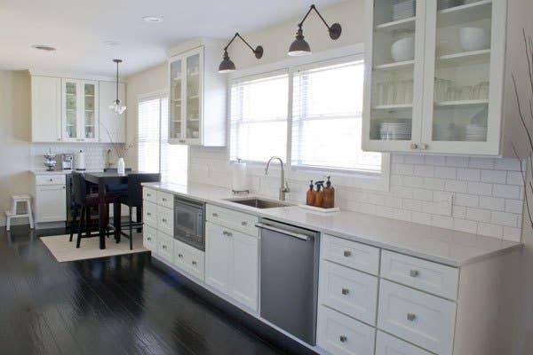 white kitchen cabinets with glass doors and white subway tile backsplash.